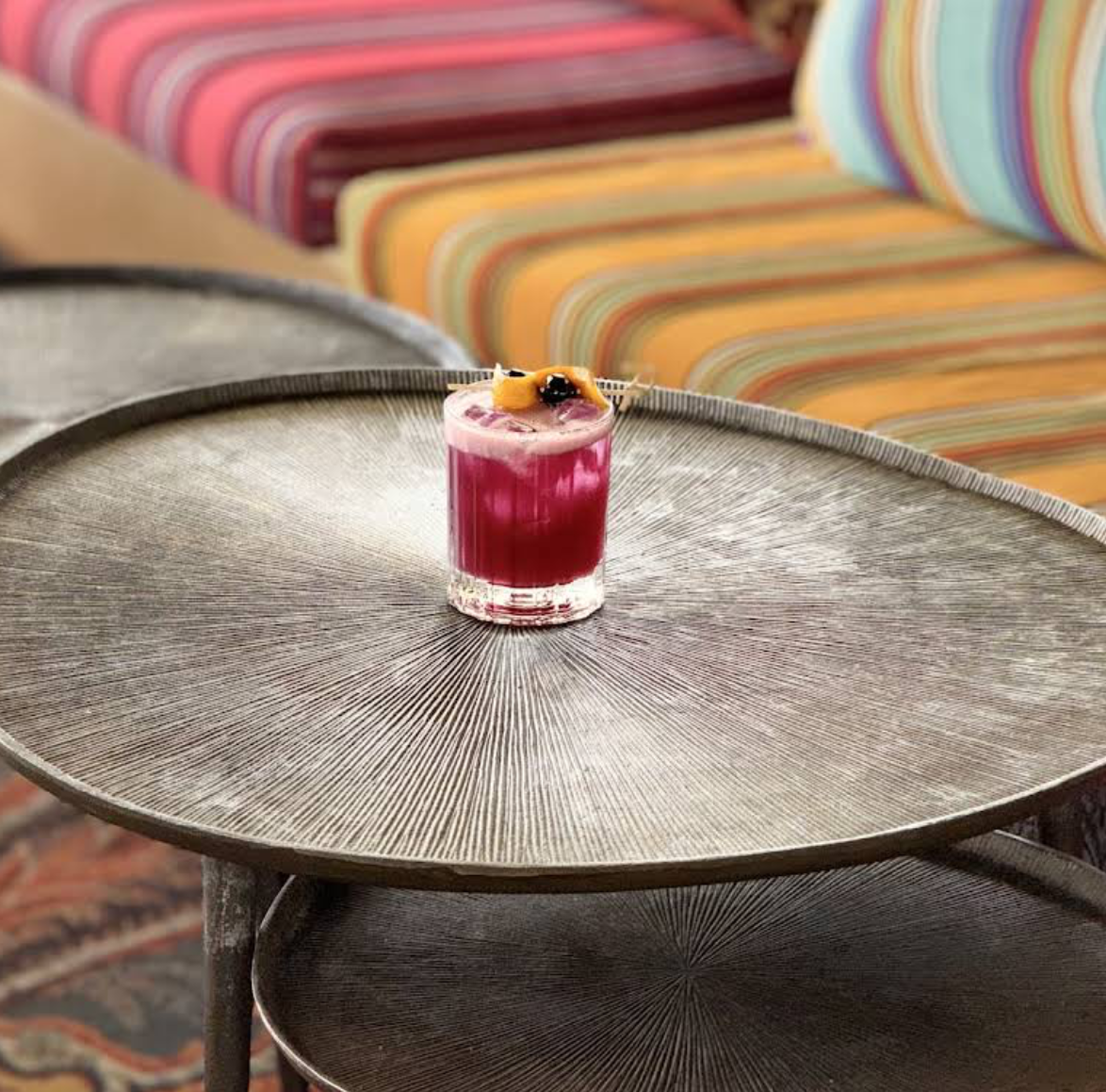 A berry cocktail on a hammered brass table