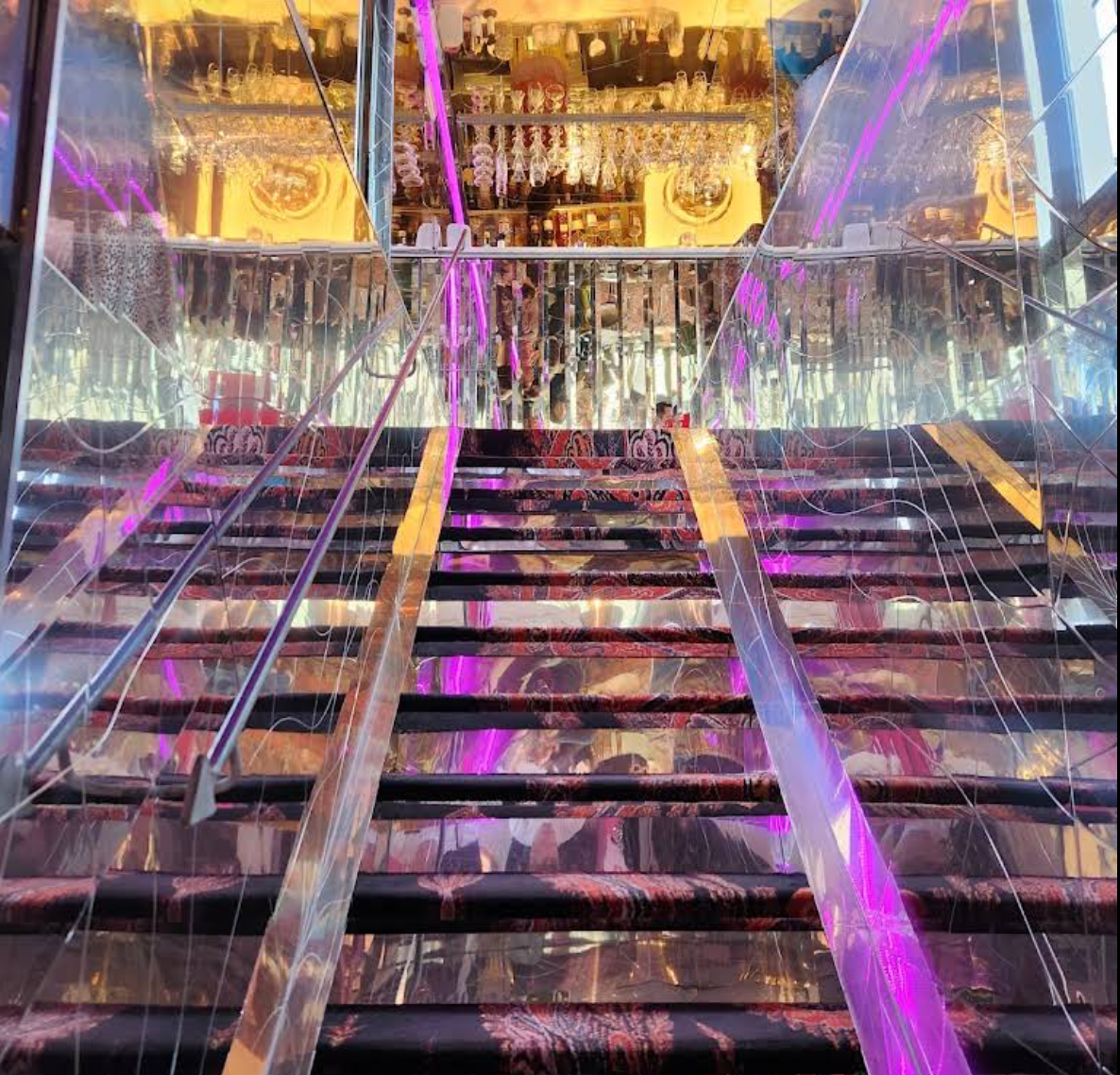 The illuminated staircase leading up to the rooftop bar