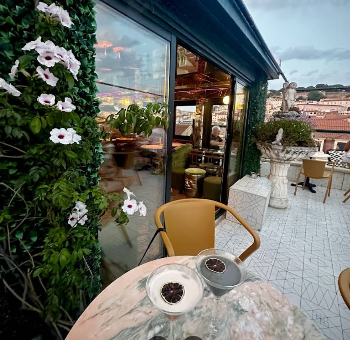 Ruby Rosa terrace at dusk with cocktails and a view over Lisbon