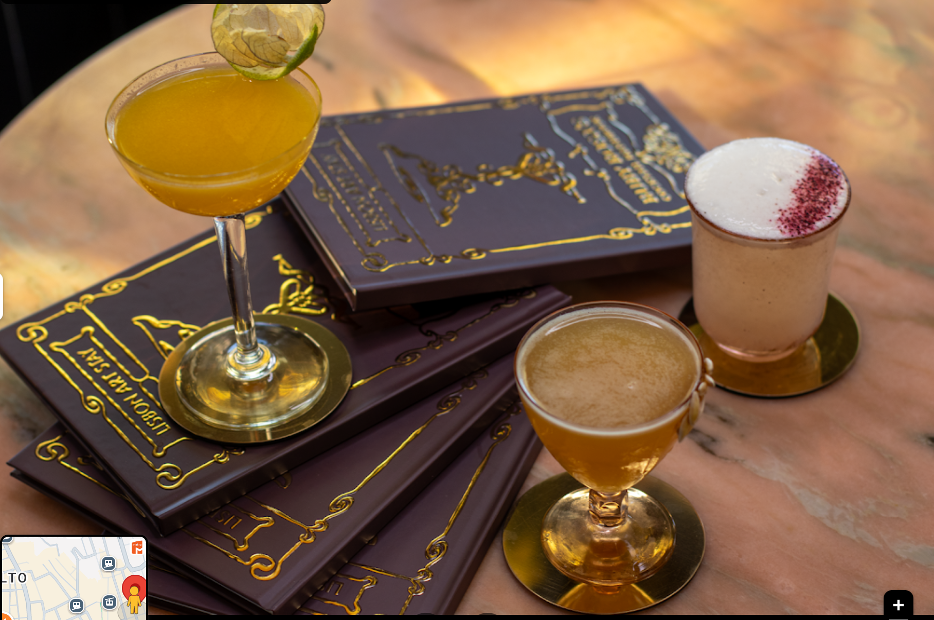 Cocktails and gilded menus on a marble table at golden hour